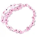 Close-up detail of translucent pink glass beads with hand-painted evil eye patterns - Pink