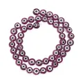 Close-up of purple flat round evil eye glass beads for DIY jewelry making accessories - Deep purple