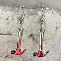 Gros plan de boucles d'oreilles marteau d'horreur d'Halloween avec taches de sang. - Style Marteau