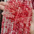Macro detail of red strawberry crystal glass beads for DIY handmade jewelry crafting. - Red