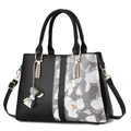Bolso tote negro de cuero sintético con estampado floral y dije de lazo metálico - 31x14x22cm / Negro