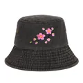 Detailed close-up of pink cherry blossom embroidery on a dark grey denim bucket hat - Black