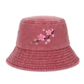 Detailed view of the embroidered cherry blossom pattern on a pink washed denim bucket hat. - Burgundy