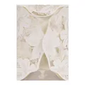 Close-up detail of white pearlescent laser-cut floral wedding invitation card - Ivory