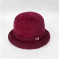 Detailed view of burgundy rabbit fur knit hat with silver metal M logo ornament. - M (56-58cm) / Wine Red (With M Logo)