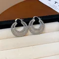 Elegant silver plated hoop earrings with intricate woven wire design in jewelry tray - 29 Earrings - Silver