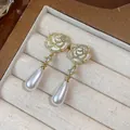 Elegant gold plated rose stud earrings with dangling teardrop pearls in a box. - 15 Silver Needles -- Gold -- White