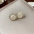 Elegant gold-plated stud earrings featuring a micro-paved zircon H letter on a shell disc - 18 Silver Needles - Gold