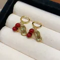Gold plated peanut drop hoop earrings with vibrant red beads in a cream jewelry box - 42 Earrings - Gold - Red