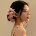 Elegant Korean style pink lily flower hair clip displayed on a model in warm light. - 59# Duckbill Clip - Pink