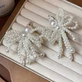 Elegant white pearl bow hair clips for women presented on a beige velvet jewelry display tray - 54# Duckbill Clip - White - Single Clip