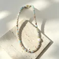 Elegant baroque pearl necklace with colorful stone beads on a beige travertine stand - Baroque Pearl Abacus Bead Faux Jade Necklace
