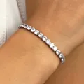 Elegant silver tennis bracelet featuring circular sparkling stones on a female wrist - Clear