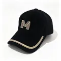 Close-up of black faux fur baseball cap with rhinestone M logo and chain brim detail. - Adult, Hat Circumference 58cm Adjustable / Black