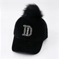 Detailweergave van zwarte winterbontpet met strass-letter D en een grote pluizige pompon - Zwart Logo Met Grote Letters / Volwassene, Hoofdomtrek 58cm Verstelbaar