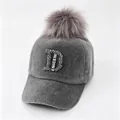 Detailweergave van een grijze nertspluche honkbalpet met strass-letter D en bontpompon - Grijs Logo Met Grote Letters / Volwassene, Hoofdomtrek 58cm Verstelbaar