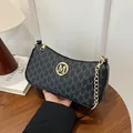 Elegant black crescent underarm bag featuring gold M logo and stylish chain strap - One Size / Black