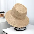 Detailed view of the intricate natural raffia straw weave on a wide-brim sun hat. - Wide Brim Bow Style (LF1048) / Beige