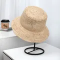 Detailed texture of high-quality handcrafted raffia straw bucket hat on display stand - Minimalist Bucket Style (LF1049) / Light Khaki