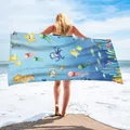 Modelo mostrando una toalla de playa de microfibra azul con bonitos estampados marinos - 75x150cm / Animales del Océano