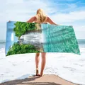 Detail of a microfiber beach towel with a waterfall print shown at a sunny beach. - 75x150cm / Landscape Waterfall