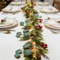 Nahaufnahme einer Weihnachtsgirlande mit roten Beeren, Zapfen und warmen LED-Lichtern. - Eukalyptusblatt Zypressenzweig Stil / Beutelverpackung