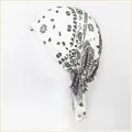 Detailed macro view of white cotton bandana headscarf with black paisley print pattern - One Size / White Paisley