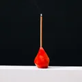 Handcrafted red crystal mineral incense holder with burning stick on black background - Red Agate Torch Style