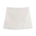Gros plan sur une mini-jupe en tweed texturé blanc cassé avec motif de tissage détaillé. - Jupe-culotte Blanche