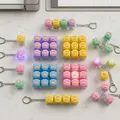 Sammlung von bunten Makronen-Katzenpfoten-Leucht-Fidget-Spielzeugen auf dem Tisch - Anpassbar / Leichtgewicht / Mehrfarbig