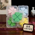 Detailed macro view of four-leaf clover stress relief keychains in various pastel colors - Box Packaging / Yellow