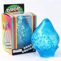 Detailed view of a blue glitter water drop squishy toy with its colorful retail box - Color Box Packaging / Blue