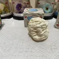 Macro detail view of white whipped cream squishy toy with its colorful packaging box - Cream Roll / Yellow