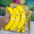 Gros plan sur trois squishies bananes jaunes avec des visages de dessins animés - Squishy Banane Souriante / Jaune (Visage Souriant)