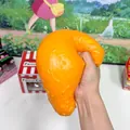 Detailed view of a hand squeezing a jumbo simulation fried chicken leg squishy toy - Jumbo Style (Bagged) / 1 Piece (OPP Bag)