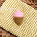 Detail shot of a pink ice cream squishy toy on a yellow checkered cloth background - Pink