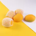 Close-up view of realistic yellow mango squeeze toys with white foam protective mesh - Mango Shape / Single Piece / Yellow