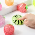 Close-up detail of hand squeezing a squishy fruit stress toy with green watermelon pattern - OPP Bag / Transparent Green Watermelon Beads
