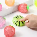 Close-up detail of hand squeezing a squishy fruit stress toy with green watermelon pattern - OPP Bag / Transparent Green Watermelon Beads