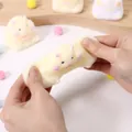 Close-up detail of a soft fuzzy hamster squishy toy being stretched for stress relief - Hamster (With Header & Bell) / 1 Piece / Yellow