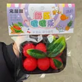 Primer plano de un juguete antiestrés realista de madroño rojo en su embalaje creativo de frutas - Tipo En Caja / Rojo
