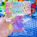 Dettaglio del giocattolo antistress a forma di tartaruga trasparente nella sua confezione colorata - Famiglia di Quattro Tartarughe / Viola