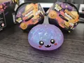 Detail view of a purple glitter ghost squishy toy placed next to its Halloween mystery boxes. - Devil Ghost