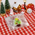 Close-up view of a cute silicone Christmas tree squeeze toy in its transparent bag. - Christmas Tree / Red