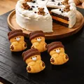 Primer plano de juguetes para apretar de silicona con forma de oso junto a un pastel - Oso Squishy (Juego de 4 Piezas) / Tostado