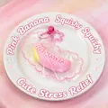 Gros plan d'un jouet anti-stress en forme de banane rose en silicone de qualité alimentaire - Gâteau Banane / Rose