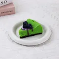 Gros plan d'un jouet squishy gâteau aux bleuets vert réaliste sur une assiette blanche - Gâteau aux Myrtilles Vert / Verdoyant