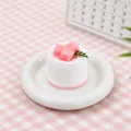 Detailed close-up of a realistic pink coconut cake squishy stress relief toy on a white plate - Coconut Cake / Pink