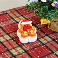 Close-up of gingerbread man squeeze toy with red scarf and Santa hat on plaid cloth. - Gingerbread Man Style