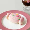 Gros plan d'un jouet de décompression en silicone en forme de bonbon sur une assiette rose - Jouet Anti-stress / Bonbon Cachemire